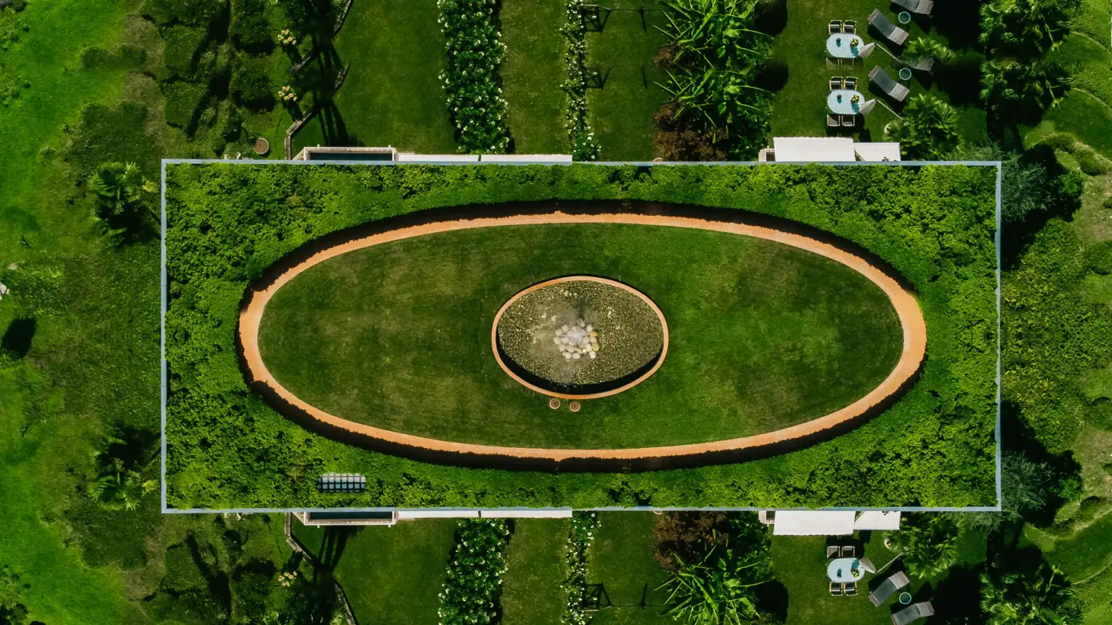 Aerial view of manicured landscaped grounds with formal lawn and hedges